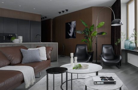 Sleek, modern living space featuring dark wood accents, stylish furniture, and lush greenery.