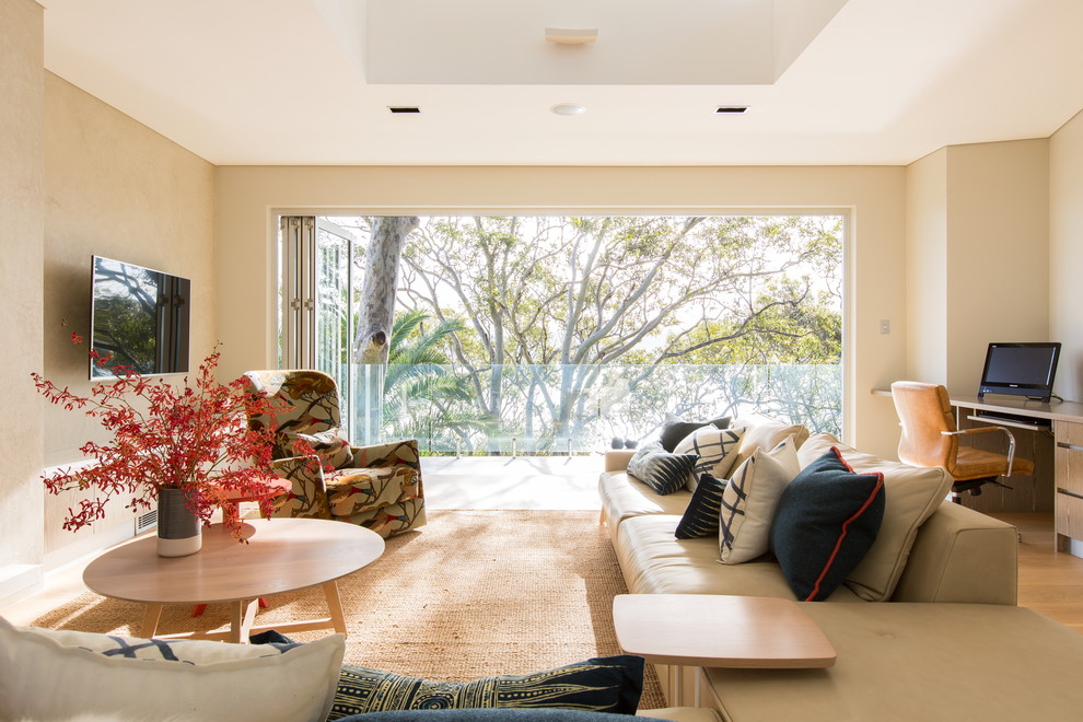 Spacious living room with large window overlooking lush greenery, modern furniture, and warm lighting.
