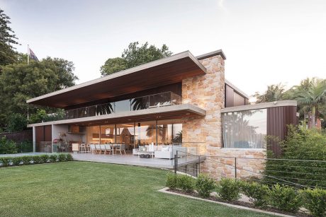 A modern, open-concept home with a spacious indoor-outdoor living space and stone walls.