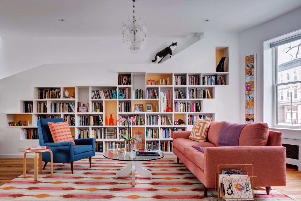 Stylish living room with built-in bookshelves, colorful rug, and modern furniture.