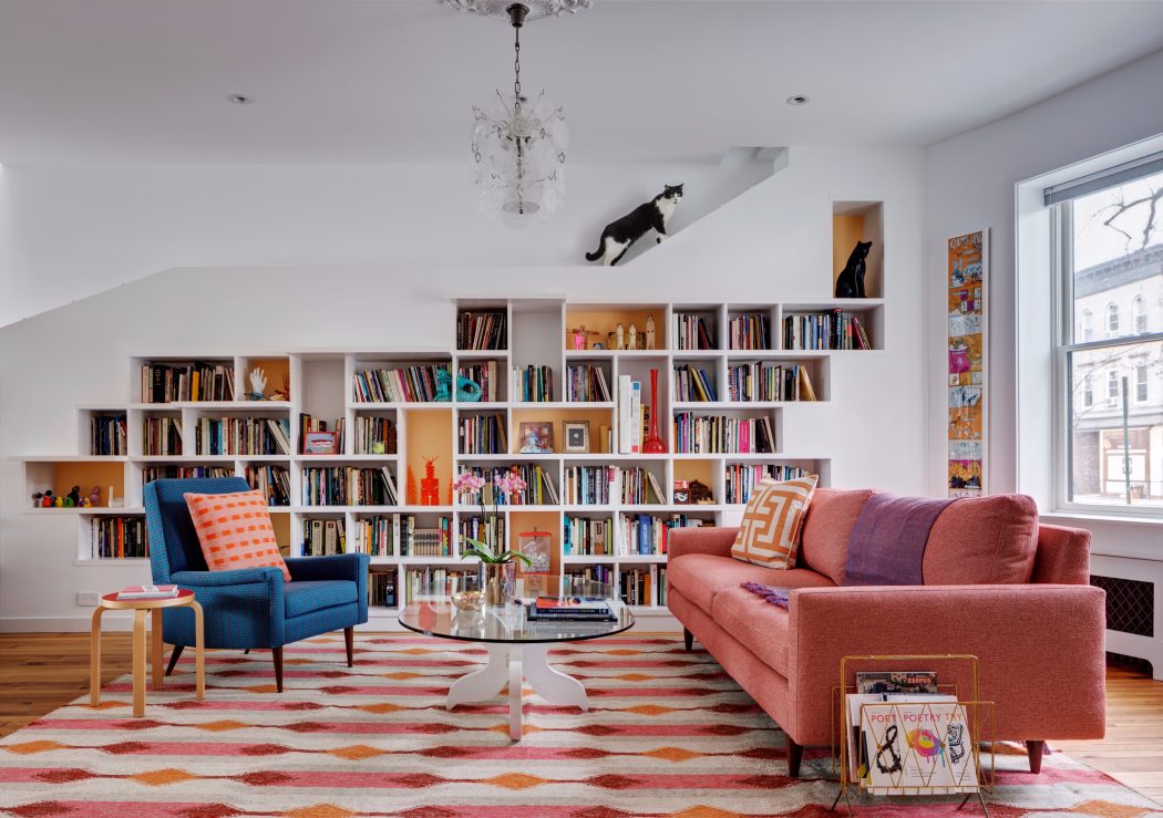 Stylish living room with built-in bookshelves, colorful rug, and modern furniture.
