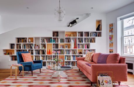 Stylish living room with built-in bookshelves, colorful rug, and modern furniture.