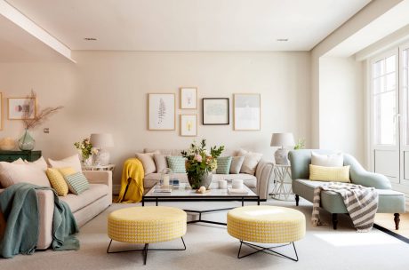 Cozy living room with soft pastel tones, framed art, and textured furnishings.