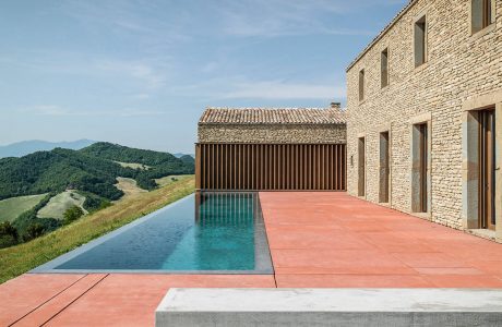 Stunning architectural design with a sleek infinity pool, stone walls, and expansive views.