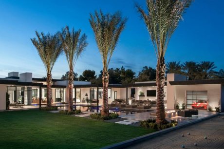 Stunning modern residence with palm trees, pool, and elegant architectural design.
