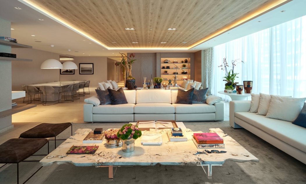Spacious living room with contemporary furnishings, wooden ceiling, and floor-to-ceiling windows.