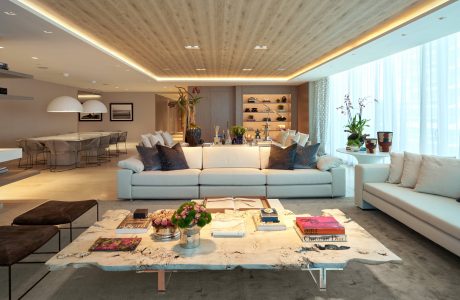 Spacious living room with contemporary furnishings, wooden ceiling, and floor-to-ceiling windows.