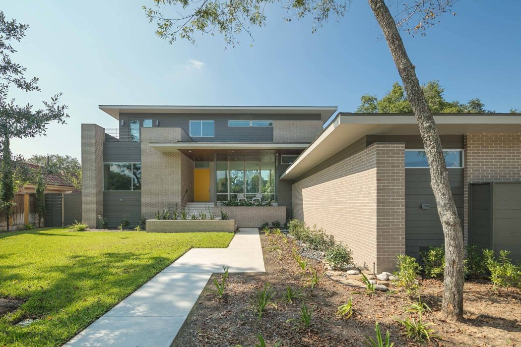 A modern, multi-level home with clean lines, large windows, and a landscaped yard.