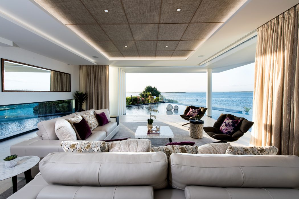 Elegant living room with plush seating, panoramic ocean view, and sophisticated decor.