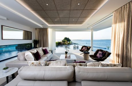 Elegant living room with plush seating, panoramic ocean view, and sophisticated decor.