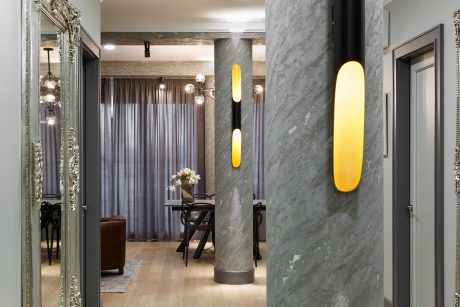 Elegant gray marble columns with yellow accent lights in a modern interior space.