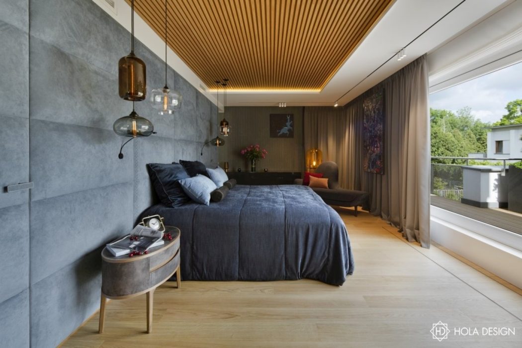 Luxurious bedroom with sleek concrete walls, warm wood ceiling, and modern lighting.