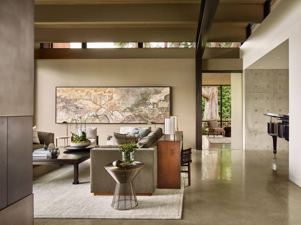 Spacious living room with concrete floors, wooden beams, and large modern artwork.