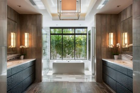 Elegant bathroom with floor-to-ceiling windows, sleek vanities, and statement lighting.