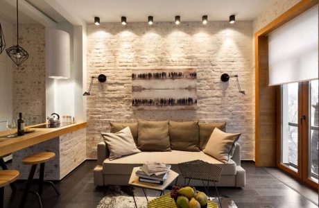 Contemporary living room with exposed brick wall, pendant lighting, and wooden accents.