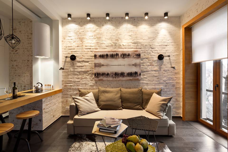 Contemporary living room with exposed brick wall, pendant lighting, and wooden accents.
