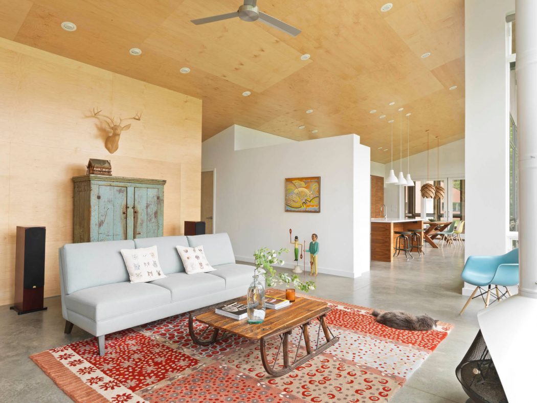 Spacious living room with vaulted ceiling, wood beams, and diverse furnishings.