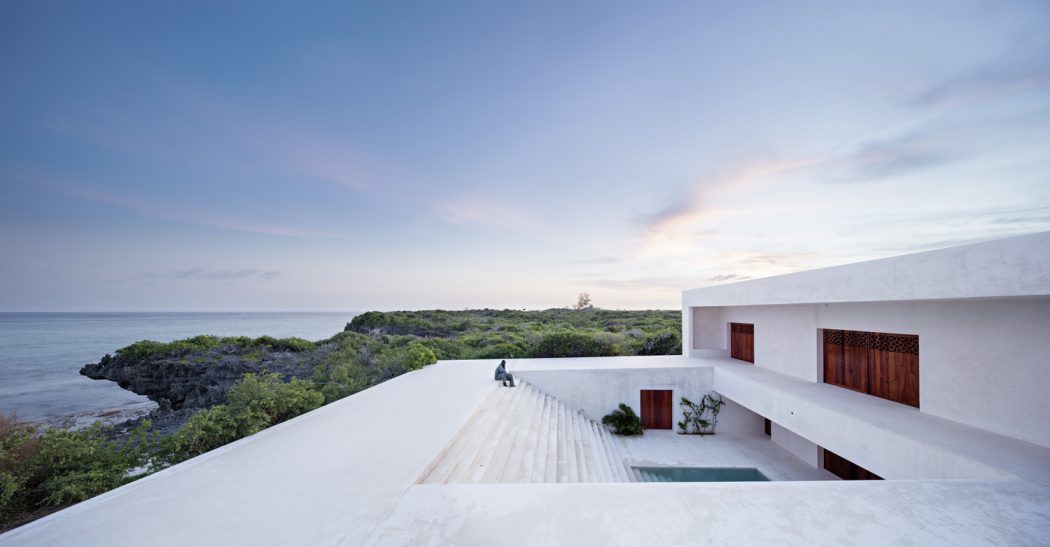 Striking modern architecture with infinity pool overlooking scenic coastline.
