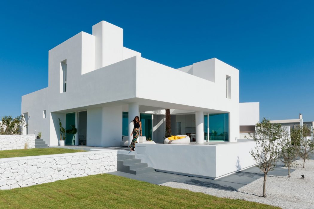 Striking modern architecture featuring geometric white facade, large windows, and spacious outdoor areas.