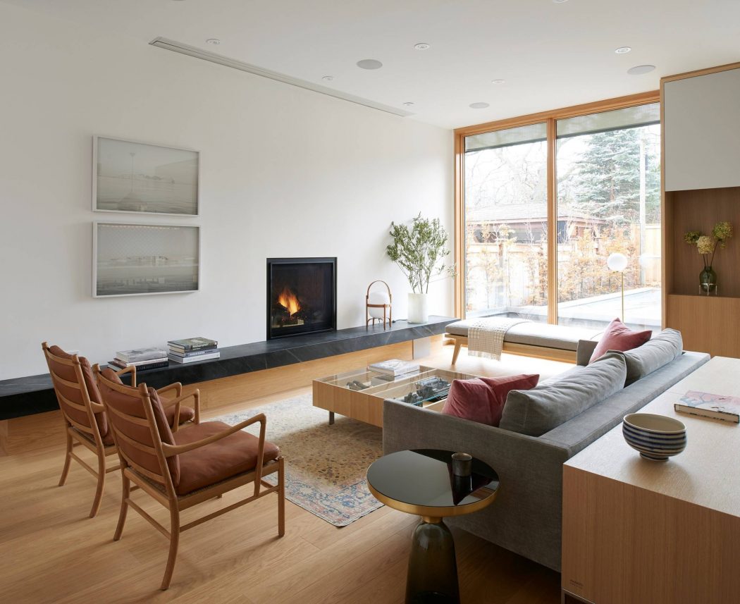 Spacious modern living room with wood tones, built-in fireplace, and large windows.