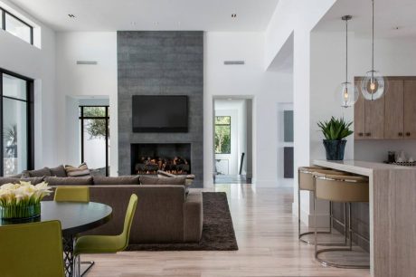 Minimalist living room with fireplace, TV, and modern furniture in neutral tones.