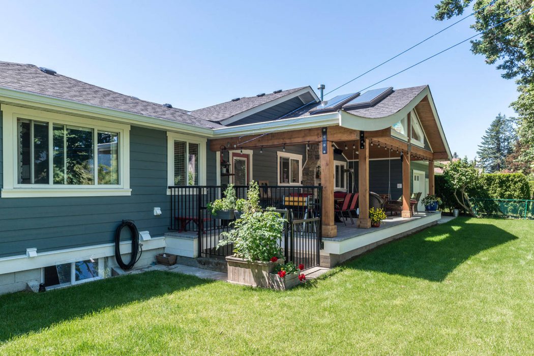 Well-designed home with a spacious porch, solar panels, and a lush, well-maintained lawn.