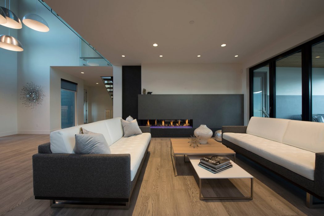 Modern living room with sleek fireplace, glass, and wood accents creating a warm, inviting space.