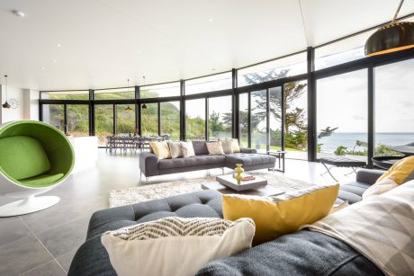 Expansive, light-filled living space with large windows showcasing scenic ocean views.