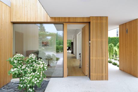 Sleek wooden exterior leading to a bright, open interior with natural elements.