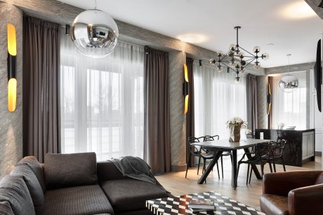 Stylish open-concept living room with modern lighting fixtures, textured walls, and sleek furnishings.