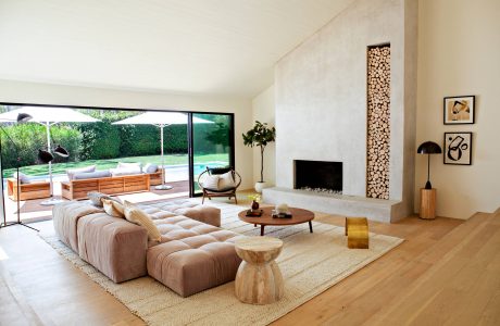 Spacious living room with large windows, fireplace, and natural wood accents.