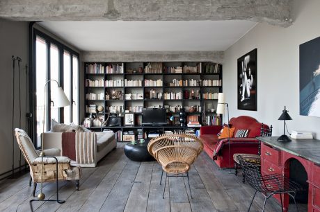 Cozy living room with large built-in bookshelves, vintage furnishings, and hardwood floors.