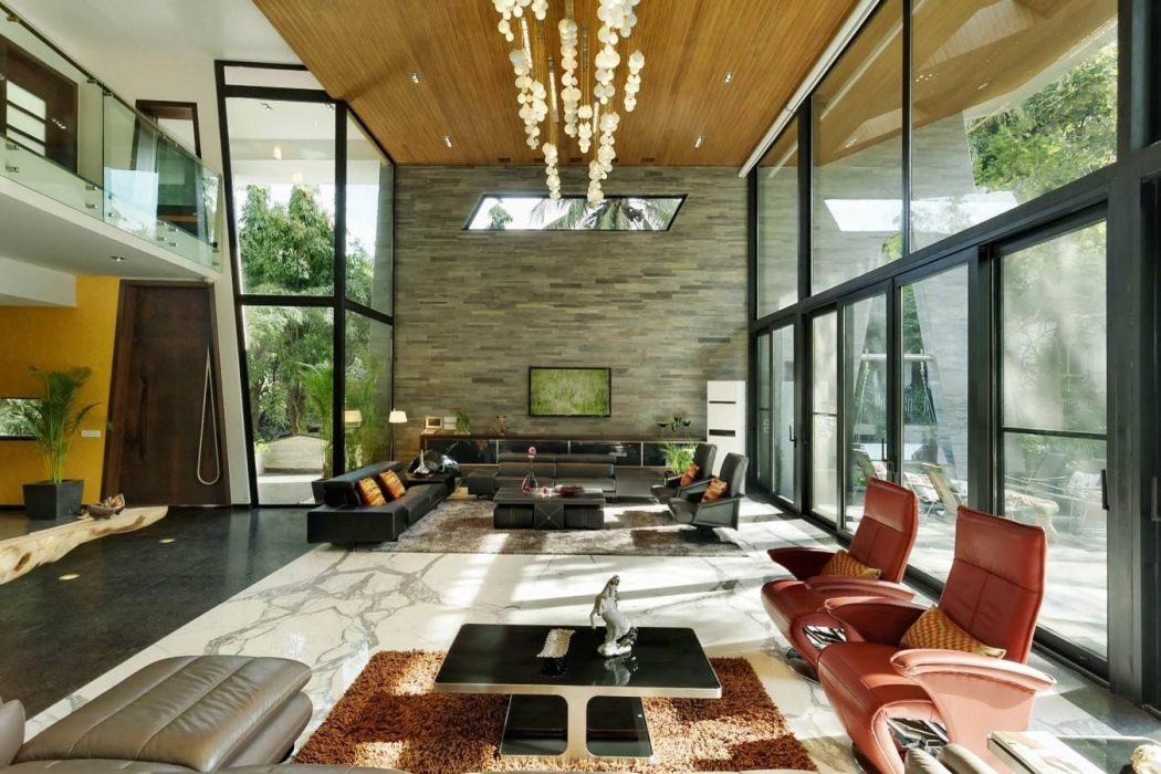 Spacious modern living room with large windows, wood ceiling, and stone wall feature.