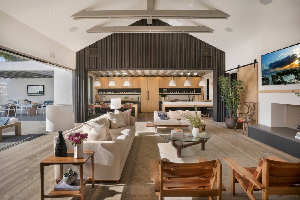 Spacious open-concept living area with high ceilings, wooden beams, and modern furnishings.