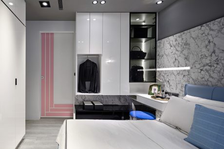 Sleek, modern bedroom with built-in wardrobe, marble accents, and minimalist furnishings.