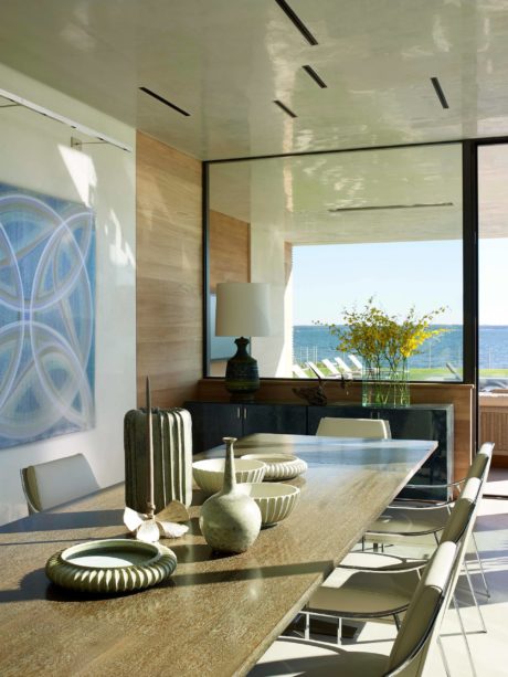 Sleek, modern dining area with large windows showcasing scenic ocean view.