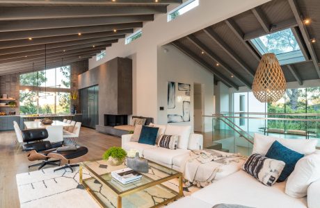 Spacious open-plan living area with soaring ceilings, exposed beams, and modern furnishings.