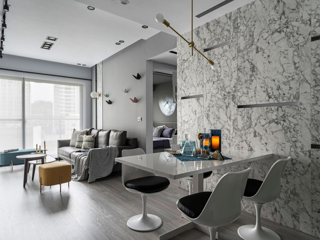 Modern living room with marble walls, sleek furniture, and warm lighting features.