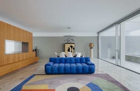 Sleek modern living room with blue tufted sofa, wood paneling, and geometric rug.