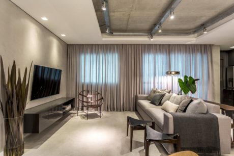 Contemporary living room with sleek concrete ceiling, neutral palette, and modern furnishings.