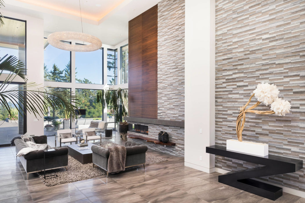 Sleek, modern living room with textured stone walls, minimalist fireplace, and plush furnishings.