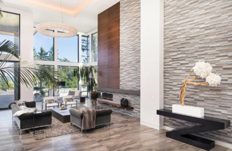 Sleek, modern living room with textured stone walls, minimalist fireplace, and plush furnishings.