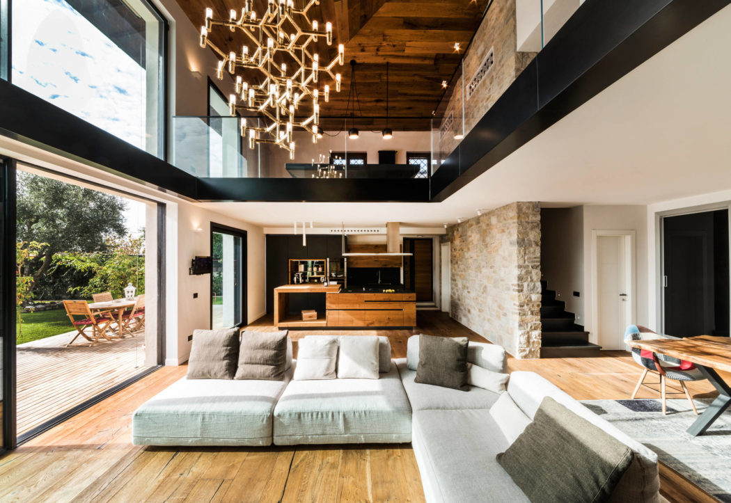 Spacious open-plan living area with high ceilings, wooden beams, and modern lighting.