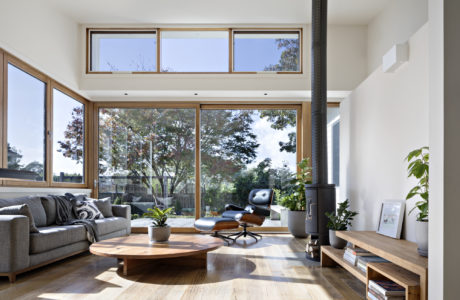 Spacious living room with modern furnishings, large windows, and outdoor views.