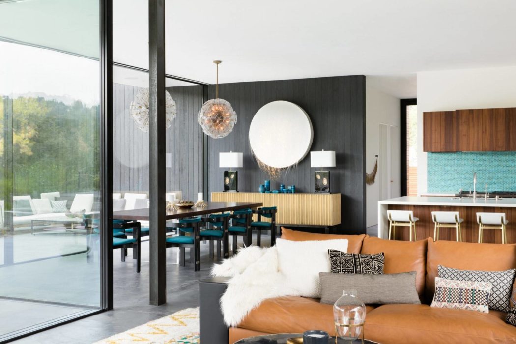Bright open-concept living space with sleek black walls, modern furniture, and floor-to-ceiling windows.
