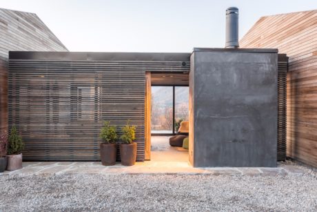 Contemporary exterior featuring slatted wood walls, concrete accents, and a cozy interior.