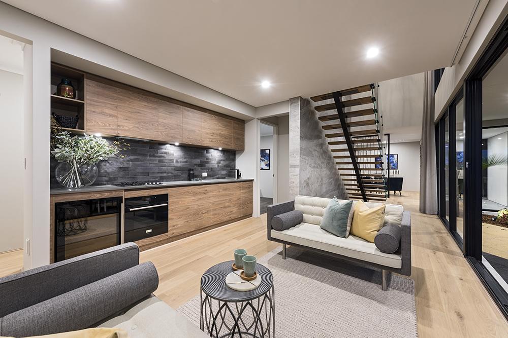 Modern open-concept kitchen, living room, and spiral staircase in a cozy, stylish home.