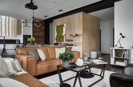 Sleek modern living space with a leather sofa, rustic wood accents, and bold lighting.