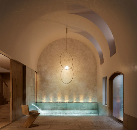 A warm, inviting space with a curved ceiling, stone walls, and a recessed lighting display.
