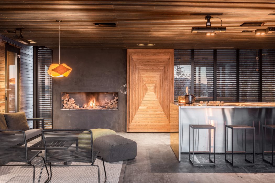 Warm, modern interior with wood accents, fireplace, and sleek kitchen design.